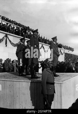 Adolf Hitler nimmt eine Parade der Wehrmacht am Tag der Wehrmacht während des Reichsparteikongresses der Freiheit im Jahr 1935. Neben Hitler beobachtet Feldmarschall Werner von Blomberg die vorbeiziehenden Truppen, in der zweiten Reihe stehen Oberbefehlshaber der Luftwaffe Hermann Göring und Oberbefehlshaber der Armee Werner von Fritsch. [Automatisierte Übersetzung] Stockfoto