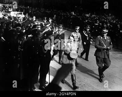 Wie immer wurde die Eröffnung des Winterhilfswerks in der Krolloper von großem Pomp begleitet, mit dem Hitler sich und die Partei inszenierte. Die Winterhilfswerk spielten in den frühen Tagen der NSDAP-Herrschaft eine wichtige Rolle, da sie sich als Überwindung von Arbeitslosigkeit und Armut im deutschen Land zeigen wollten. Neben Hitler sein damals Chefadjutant Wilhelm Brückner in SA-Uniform. In der zweiten Reihe Julius Schaub, der später diesen Posten befüllte. [Automatisierte Übersetzung] Stockfoto