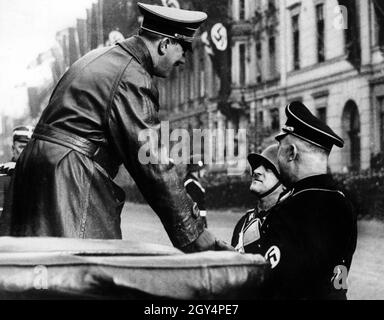 Adolf Hitler dankt dem Kommandanten der Leibstandarte Adolf Hitler, Obergruppenführer Sepp Dietrich, für die Parade zu seinem Geburtstag. Reichsführer SS Heinrich Himmler steht zur Verfügung. [Automatisierte Übersetzung] Stockfoto