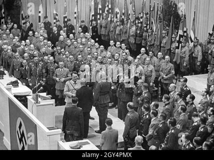 'Am 4. Oktober 1942, dem Thanksgiving-Tag, hielt Reichsmarschall Hermann Göring (Mitte, am Rednerpult) eine 'Thanksgiving-Rede' im Sportpalast in Berlin-Schöneberg. In der Rede versicherte er, im kommenden Winter Nahrung für das ''deutsche Volk'' zu sichern. Rechts hinter Göring steht Landwirtschaftsminister Herbert Backe und vermutlich Joseph Goebbels in der Mitte unten im Bild. Auf dem Bild verleiht Göring dem Bauernführer Ernst Ritter (schwarzer Anzug) und dem Bauernführer Fritz Leffler (rechts neben ihm) das Ritterkreuz des Verdienstordens des Krieges. Stockfoto