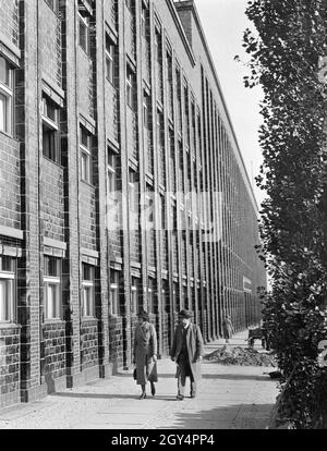 Ein Mann und eine Frau blicken auf die façade des Berliner Rundfunkhauses (heute: Haus des Rundfunks) in der Masurenallee in Berlin-Westend. Das Foto wurde am 2. November 1937 aufgenommen. [Automatisierte Übersetzung] Stockfoto