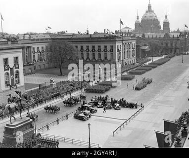 Soldaten eines Infanterieregiments marschieren an Adolf Hitler vorbei, der auf einem Podium vor der Universität (Mitte) steht. Die Militärparade am 20. April 1938 auf der Straße unter den Linden führt (von links nach rechts) an der Humboldt-Universität, der Gedenkstätte (heute Neue Wache) und der Waffenkammer vorbei. Dahinter ist die Kuppel des Berliner Doms zu sehen. Links unten befindet sich die Reiterstatue Friedrichs des Großen, vor der sich Film- und Kamerateams der Presse aufgereiht haben. [Automatisierte Übersetzung] Stockfoto