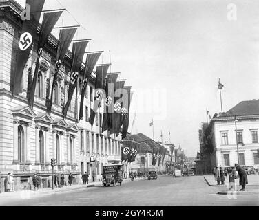 'Das Foto zeigt die Reichskanzlei (bestehend aus der Alten Reichskanzlei, dem Erweiterungsbau und dem Palais Borsig, links im Bild) in Berlin-Mitte, die am 10. Mai 1938 mit Hakenkreuzfahnen aufgehängt wurde, kurz bevor Adolf Hitler aus Italien zurückkehrte. Ein Teil des Prinz-Karl-Palais, in dem sich das Reichsministerium für Volksaufklärung und Propaganda befand, ist auf der rechten Seite zu sehen. Der Blick geht nach Norden. Ein Lieferwagen der Firma 'Rahn und Co. Büromöbel' hält vor dem neuen Teil der Reichskanzlei. [Automatisierte Übersetzung]' Stockfoto