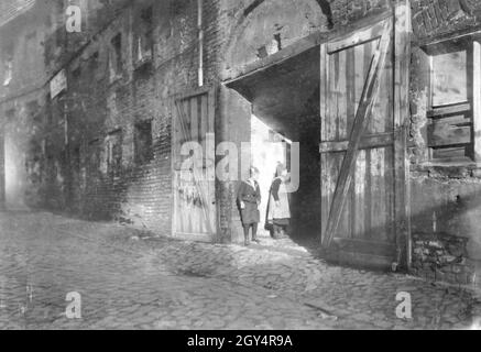 Zwei Kinder stehen 1907 in einem baufälligen Hofeingang in der Gasse am Krögel in Berlin-Mitte, blicken in die Dunkelheit und warten auf weitere Kinder. [Automatisierte Übersetzung] Stockfoto