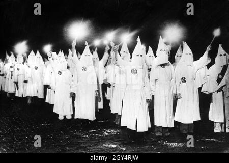 Um die afroamerikanischen Wähler vor den nächsten Kommunalwahlen einzuschüchtern, marschieren Mitglieder des Ku Klux Klan nachts mit Fackeln durch St. Petersburg im US-Bundesstaat Florida. [Automatisierte Übersetzung] Stockfoto