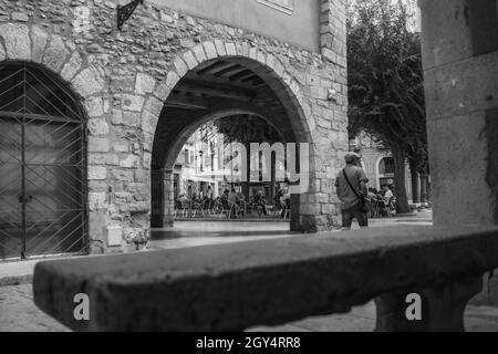 MONTBLANC, SPANIEN - 12. SEPTEMBER 2021: Schwarz-weiß Vintage Straßenbild von Menschen auf der Straße und im Café Stockfoto