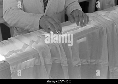 Hände des Vorarbeiters Fallschirm in einer Näherei, Deutschland 1940er Jahre. Hände von einem häuptling an einem Fallschirm nähen Fabrik, Deutschland 1940. Stockfoto