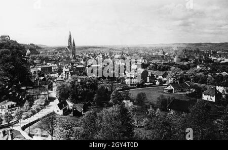 Der Blick geht vom Höglberg südwestlich auf die Altstadt von Landshut, die links vom Hofberg mit Schloss Trausnitz begrenzt wird. Die Jesuitenkirche St. Ignatius, die Kirche St. Martin, die Kirche St. Jodok und die Kirche Christi heben sich von der Stadt ab (von links nach rechts). Vorne links sehen Sie die Schönbrunner Straße. Undatierte Aufnahme, wahrscheinlich um 1930 aufgenommen. [Automatisierte Übersetzung] Stockfoto