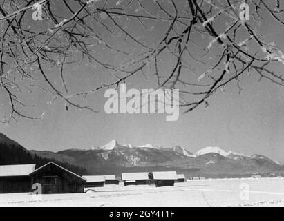 Das Bild der schneebedeckten Landschaft entstand im Winter 1936 südlich von Garmisch. Der Blick geht nach Westen nach Grainau, im Hintergrund sieht man die Oberleiten und den Hohen Seeberg, dahinter Daniel, Rauher Kopf und Spitziger Brand (jeweils von links). [Automatisierte Übersetzung] Stockfoto