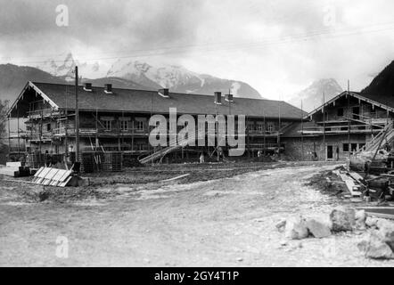 'Am 11. Mai 1937 war der Neubau der Reichskanzlei (Berchtesgadener Büro) in Bischofswiesen am Fuße des Watzmann (hinterer Hintergrund, Grünstein vorne links) fast fertig. Auf dem Gerüst des Gebäudes, das nach Plänen von Alois Degano errichtet wurde, hängt ein Plakat der Deutschen Arbeitsfront: 'Diese Firma steht in der Deutschen Arbeitsfront vereint'. [Automatisierte Übersetzung]' Stockfoto