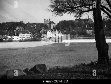 Das Foto wurde 1934 am Westufer des Lech aufgenommen und zeigt das Wehr vor der Altstadt von Landsberg am Lech. Auf dem hohen Ufer auf der anderen Seite des Flusses befinden sich die Heilig-Kreuz-Kirche und das ehemalige Jesuitengymnasium. [Automatisierte Übersetzung] Stockfoto