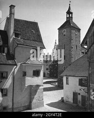 'Auf diesem Foto geht der Blick vom unteren zum oberen Schrannenplatz in Lindau, wo auch die Peterskirche steht. Auf der linken Seite befindet sich das ''Haus zur Glogge'', ehemals eine Glockengießerei. Undatierte Aufnahme, wahrscheinlich um 1930 aufgenommen. [Automatisierte Übersetzung]' Stockfoto