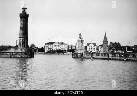 Das Foto aus dem Jahr 1913 zeigt die Hafeneinfahrt zum Hafen von Lindau am Bodensee, die vom Neuen Leuchtturm und dem Bayerischen Löwen begrenzt wird. Weiter rechts befindet sich der Mangturm. Das Gebäude in der Mitte des Bildes ist das Hotel Bayerischer Hof, weiter rechts ist das Hotel Reutemann zu sehen. [Automatisierte Übersetzung] Stockfoto