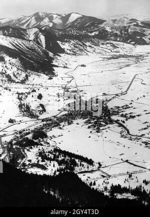 Der Blick vom 6. Februar 1936 von der Starnberger Hütte auf den Laber hinunter nach Oberammergau und Unterammergau (im Hintergrund). Die beiden Dörfer sind durch eine Eisenbahnlinie miteinander verbunden. Der begradigte Ammer fließt durch das Tal. Im Hintergrund erheben sich die Trauchberge, rechts die Hochschergen. [Automatisierte Übersetzung] Stockfoto