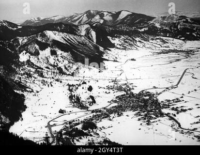 Der Blick vom 6. Februar 1936 von der Starnberger Hütte auf den Laber hinunter nach Oberammergau und Unterammergau (im Hintergrund). Die beiden Dörfer sind durch eine Eisenbahnlinie miteinander verbunden. Der begradigte Ammer fließt durch das Tal. Im Hintergrund erheben sich die Trauchberge, rechts die Hochschergen. [Automatisierte Übersetzung] Stockfoto