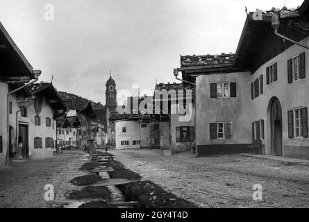 Der Blick geht vom Obermarkt in Mittenwald auf die Pfarrkirche St. Peter und Paul in der Matthias-Klotz-Straße. Das Foto wurde wahrscheinlich um 1915 aufgenommen. [Automatisierte Übersetzung] Stockfoto