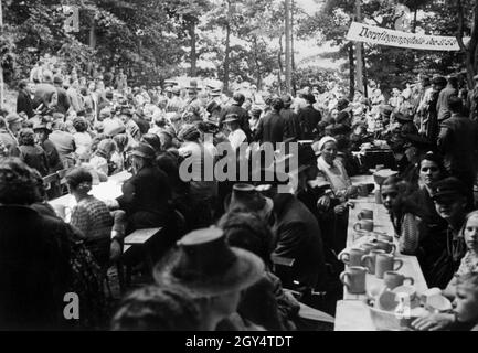 „die Bewohner kehren nach Merzig/Saar zurück und feiern ihre gemeinsame Heimkehr in einem Biergarten. Auf dem Banner steht ''NSV Catering Station''. [Automatisierte Übersetzung]' Stockfoto