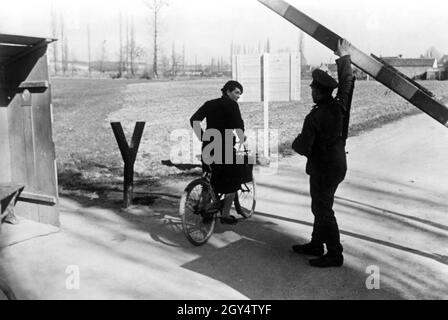 Grenzposten an der Grenzlinie zwischen Nord- und Südfrankreich: Ein Soldat hebt die Barriere für einen Passanten, der durchkommt. [Automatisierte Übersetzung] Stockfoto