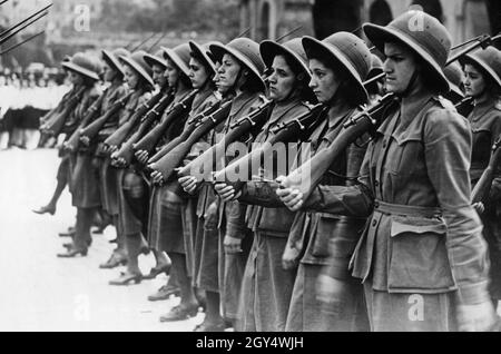 Am 26. Oder 27. Mai 1939 fand in Rom eine große Parade von Zehntausenden faschistischen Frauen vor Mussolini statt. Das Bild zeigt eine Frauenpartie mit faschistischen Fusiliers. Sie tragen Gewehre und Helme. [Automatisierte Übersetzung] Stockfoto