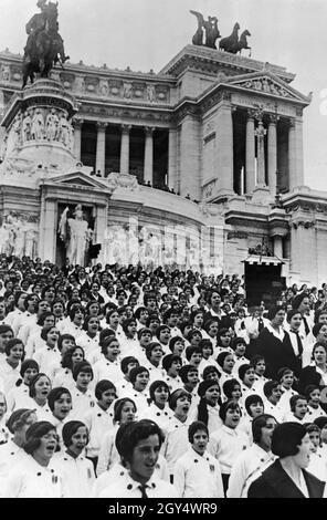 „auf den Stufen des Vittoriano in Rom im Jahr 1933 versammelten sich zahlreiche Kinderchören, um gemeinsam zu singen. Die Mädchen im Alter von 8 bis 13 Jahren waren Teil der "Piccole italiane" der faschistischen Jugendorganisation Opera Nazionale Balilla. [Automatisierte Übersetzung]' Stockfoto