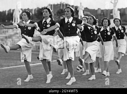 "Junge Frauen der faschistischen "Opera nazionale del dopolavoro" (OND) üben den Bohrschritt im Marmorstadion auf dem Foro Mussolini (heute Foro Italico) in Rom. Mussolini hatte in diesem Jahr den 'passo romano' eingeführt, ein Paradeschritt, der dem der deutschen Wehrmacht sehr ähnlich war. Die OND war die Freizeit- und Freizeitorganisation der italienischen Faschisten und die faschistische Massenorganisation mit der größten Anzahl von Mitgliedern. [Automatisierte Übersetzung]' Stockfoto