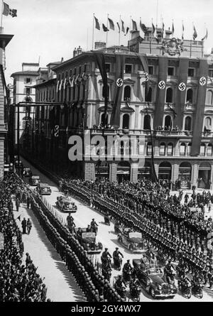 Adolf Hitler besuchte Italien, verbündet mit Nazi-Deutschland, Anfang Mai 1938. Am Dienstag, den 10. Mai 1938, fuhr er mit Benito Mussolini (beide im vorderen Wagen stehend) durch die festlich geschmückten Straßen von Florenz. Die Säule kommt aus der Via degli Speziali und fährt auf die Piazza della Repubblica. [Automatisierte Übersetzung] Stockfoto