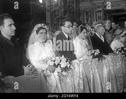 Am 31. Januar 1942 fanden in der Kirche Santa Maria del Carmine Maggiore in Neapel vier Hochzeiten statt. Bei dieser Gelegenheit wurden vier Soldaten, die an der Front für Italien waren, per Fernehe mit ihren Frauen verheiratet. Die Soldaten gaben ihre Autorität für die Ehe per Radioübertragung. Das Bild zeigt die Zeremonie in der Kirche, an der die Bräute ohne ihre zukünftigen Ehemänner teilnehmen müssen. [Automatisierte Übersetzung] Stockfoto