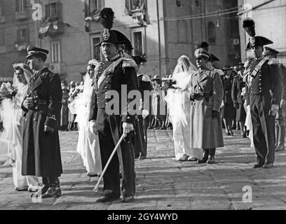 Am 31. Januar 1942 fanden in der Kirche Santa Maria del Carmine Maggiore in Neapel vier Hochzeiten statt. Bei dieser Gelegenheit wurden vier Soldaten, die an der Front für Italien waren, per Fernehe mit ihren Frauen verheiratet. Die Soldaten gaben ihre Autorität für die Ehe per Radioübertragung. Das Bild zeigt den Hochzeitszug der Bräute auf der Piazza del Carmine. Angehörige der Armee begleiten die Frauen in die Kirche. [Automatisierte Übersetzung] Stockfoto