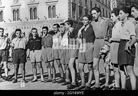 „das Foto zeigt eine Gruppe junger Menschen, die am 16. September 1940 vor dem Palazzo delle Assicurazioni Generali auf der Piazza Venezia in Rom stehen. Sie tragen Shorts und kurze Hemden. Diese "neue Mode" sollte den faschistischen Bemühungen der Autarchie helfen, den italienischen Markt mit Textilien zu versorgen. [Automatisierte Übersetzung]' Stockfoto