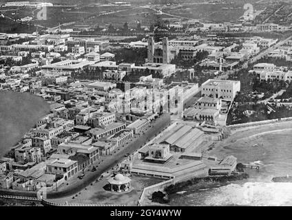 Die Luftaufnahme zeigt das Zentrum der Kolonialstadt Mogadischu, der Hauptstadt des italienischen Somaliland. Links hinter der Kirche befindet sich ein Flugplatz. Der Hafen der Stadt war ein Marinestützpunkt für die italienische Marine. Das undatierte Foto wurde wahrscheinlich in den 1930er Jahren aufgenommen. [Automatisierte Übersetzung] Stockfoto