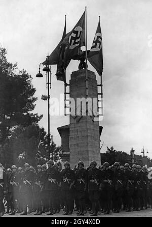 1938 besuchte eine faschistische Delagation aus Italien Berlin, die Hauptstadt des alliierten Nazi-Deutschlands. Auf dem Bild stehen die Offiziere in Formation vor einer Säule mit Hakenkreuzsymbolen. [Automatisierte Übersetzung] Stockfoto