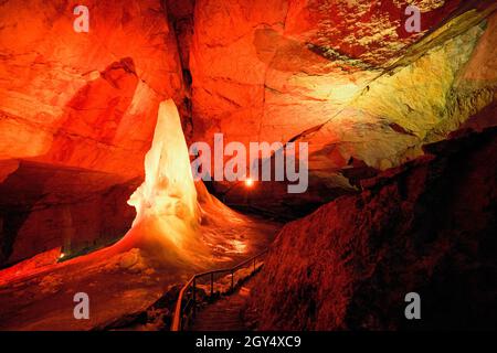 Lichtshow über Eisformationen und eine hohe Eisspitze im Parzivaldom an der Dachstein Rieseneishöhle, einer riesigen Eishöhle in den österreichischen Alpen Stockfoto