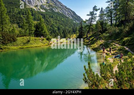 Wanderer entspannen sich am Ufer des Märchensees, buchstäblich Märchensee, auf der Tauplitzalm, Tauplitz, Ausseer Land, Österreich Stockfoto