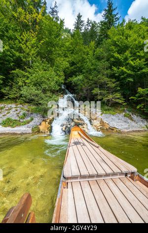 Wasserfall (Traun-Ursprung), der in den legendären Toplitz-See, Ausseer Land, Steiermark, Österreich, von einem traditionellen Boot Plätzte aus gesehen, einstürzt Stockfoto