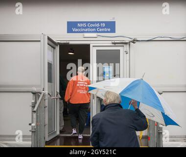 Ältere Menschen, die sich vor einem NHS Covid-19 Impfzentrum in London, England, anstellen Stockfoto