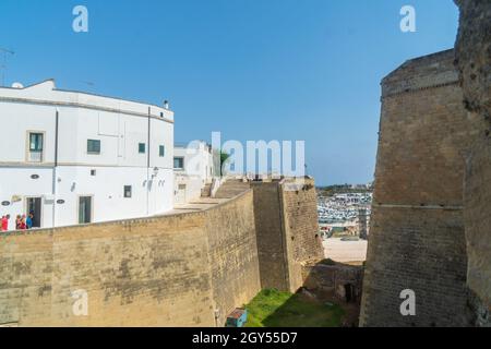 Otranto, Apulien, Italien - 17. August 2021: Blick auf den runden Turm und die Mauern des antiken Aragon-Schlosses, umgeben von einem tiefen Graben und einem Festungswal Stockfoto