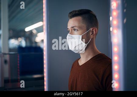 Sicherheitskontrolle am Flughafen. Porträt der Passagiere, die durch das Tor des Metalldetektors. Stockfoto