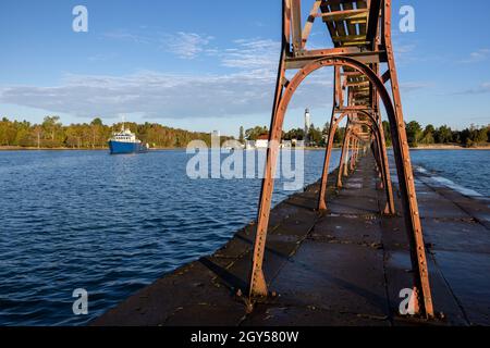 Ein Boot, das an einem Leuchtturm vorbei auf den Lake Michigan fährt. Stockfoto