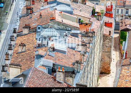 Ziegeldächer der Altstadt . Blick auf den alten Stadtteil von Bordeaux von oben. Antennen und Klimaanlagen auf den Dächern Stockfoto