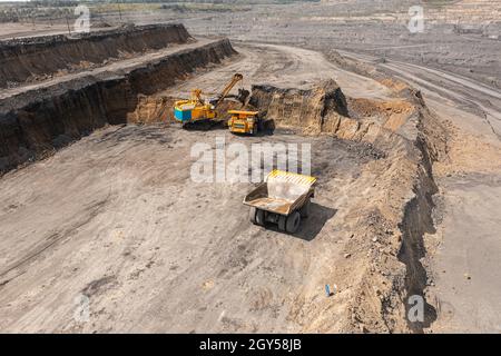 Panorama-Luftaufnahme der Kohlebergwerk. Tagebauminenindustrie, großer gelber Bergbau-LKW für Steinbruch. Offener Kohlebergbau Anthrazit Bergbau. Grube auf Kohle Stockfoto