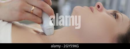 Arzt, der Ultraschall der Schilddrüse an junge Frau in der Klinik Stockfoto