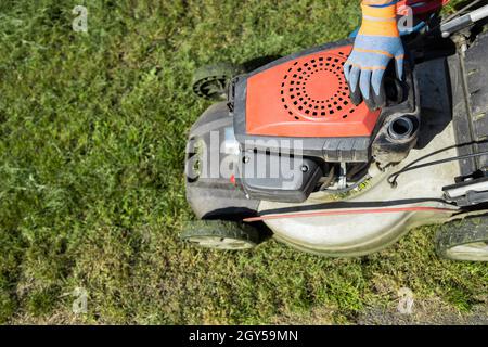Der Gärtner öffnete den Kraftstoffeinfüllstutzen des Mähers Stockfoto
