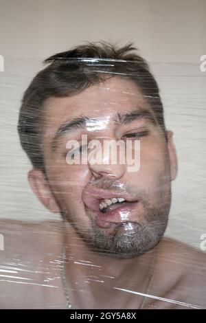 Mans Kopf in Lebensmittelbehälter. Ein Mann Gesicht in einer Lebensmittelverpackung. Stockfoto