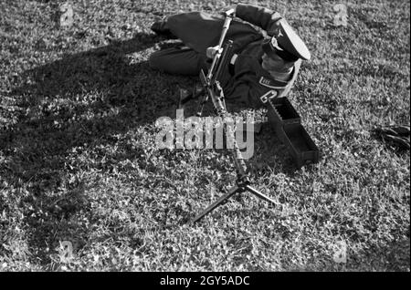 Der Ausbilder Feldwebel erläutert das Vorgehen bei einem Laufwechsel bin Maschinengewehr MG 34, Deutschland 1930er Jahre. Der Drill Sergeant erläutert die Änderung der Kanonen auf dem Maschinengewehr MG 34, Deutschland 1930. Stockfoto