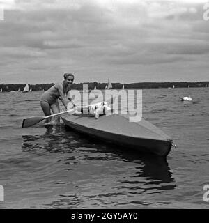 Werbefoto für KLEPPER Faltboot padelt: eine junge Frau mit einem Welpen in einem Sehen, Deutschland 1930er Jahre. Werbung für ein Klepper foldboat: eine junge Frau mit einem Belgaqueen paddeln auf einem See, Deutschland 1930. Stockfoto