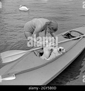 Werbefoto für KLEPPER Faltboot: eine junge Frau padelt mit zwei Welpen in einem Sehen, Deutschland 1930er Jahre. Werbung für ein Klepper foldboat: eine junge Frau mit zwei Welpen paddeln auf einem See, Deutschland 1930. Stockfoto