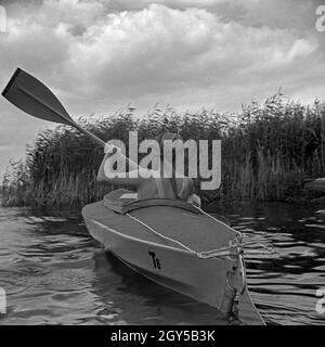 Werbefoto für KLEPPER Faltboot: eine junge Frau paddelt mit einem Welpen in einem Sehen, Deutschland 1930er Jahre. Werbung für ein Klepper foldboat: eine junge Frau mit einem Welpen paddeln auf einem See, Deutschland 1930. Stockfoto