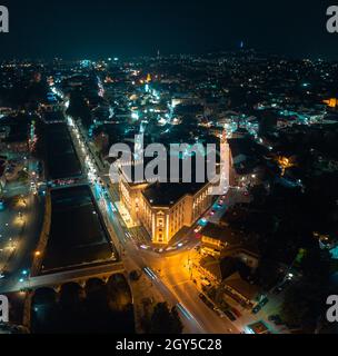 Drohnenansicht der Innenstadt von Sarajevo, des Rathauses und des Flusses Miljacka am Abend Stockfoto