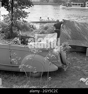 Mit dem Ford V8 unterwegs bin Siehe zum Zelten, Deutschland 1930er Jahre. Mit einem Ford V8 am Ufer eines Sees und ein Zelt, Deutschland 1930. Stockfoto