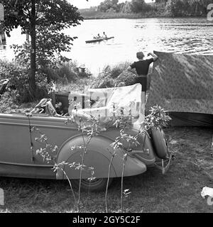 Mit dem Ford V8 unterwegs bin Siehe zum Zelten, Deutschland 1930er Jahre. Mit einem Ford V8 am Ufer eines Sees und ein Zelt, Deutschland 1930. Stockfoto